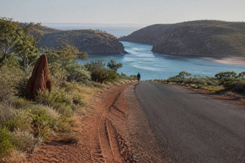 Sealed road running north through red dirt country and low scrub on the Dampier Peninsula