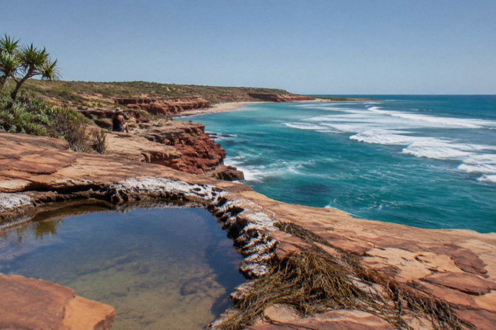 Turquoise water and red cliffs along a remote peninsula coastline
