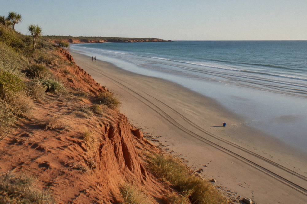 Red pindan cliffs along Cable Beach under a wide clear sky in the dry season