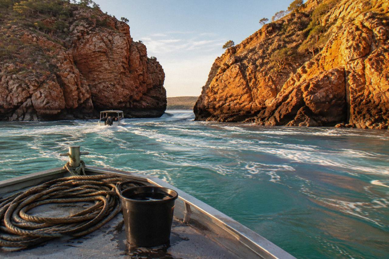 Turquoise water rushing through a narrow coastal gorge in the Kimberley at golden light