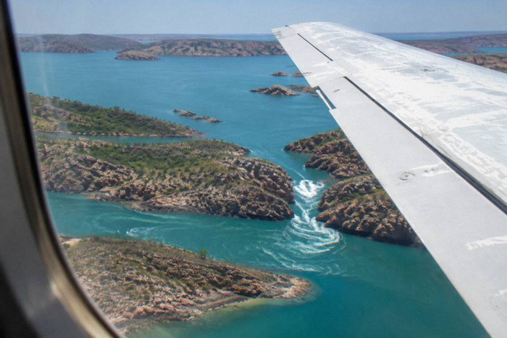 Aircraft wing above the turquoise island-studded waters of the Buccaneer Archipelago