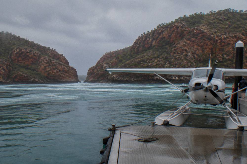 Seaplane moored beside a floating pontoon in a remote Kimberley bay