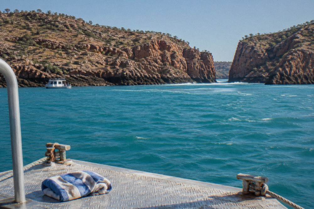 A floating seaplane pontoon moored beside red cliffs in a remote bay