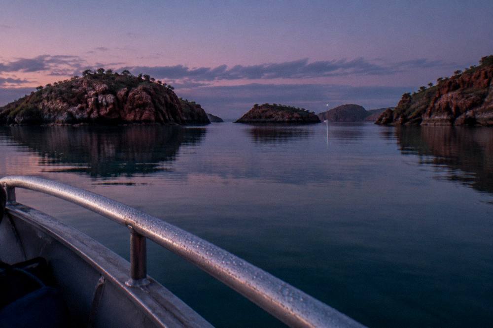 Red rock islands of the Buccaneer Archipelago scattered across a turquoise sea at dawn