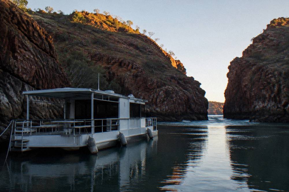 A floating pontoon moored in a narrow bay between steep rock walls