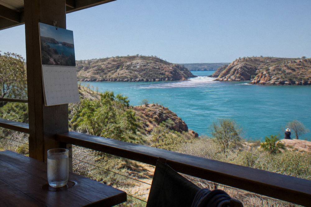 A wall planner showing dry season dates beside a bright blue sky over a turquoise Kimberley bay