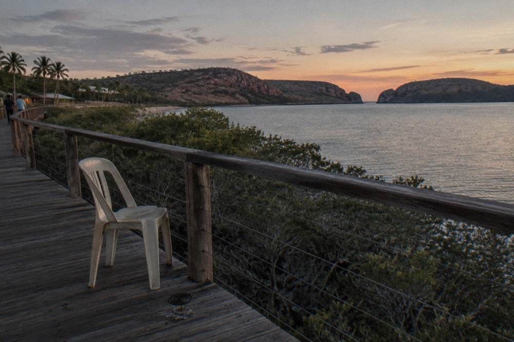 Boardwalk and viewing platform above mangroves along a sheltered bay at dusk