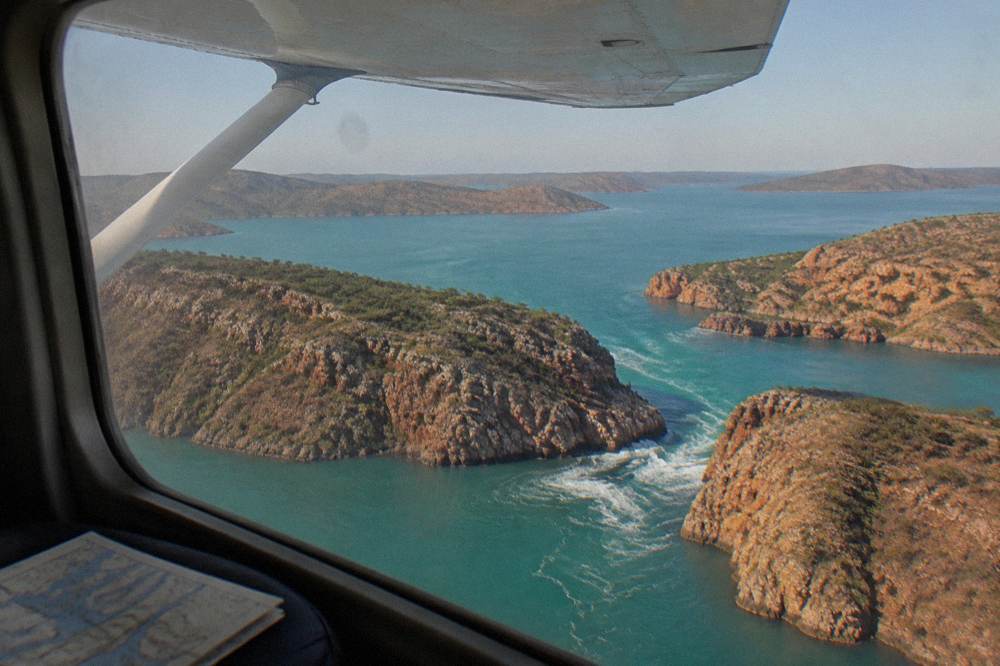 Light aircraft flying over islands and turquoise bays
